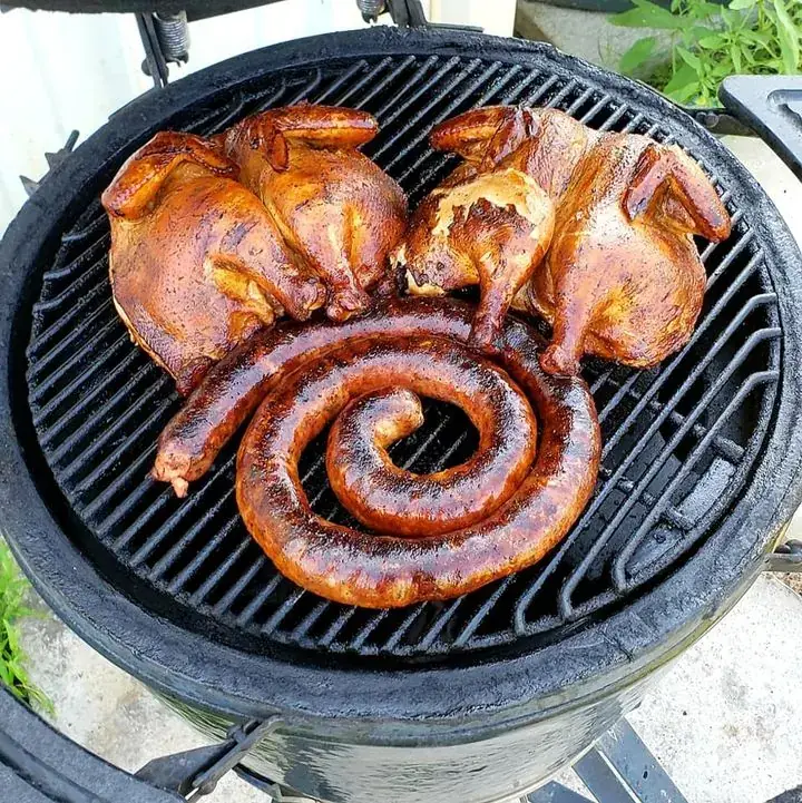 Smoked chickens and a coil of sausage on the grill